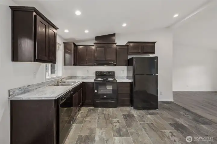 This view from the dining nook shows how open and adaptable the layout really is. The sightlines into the living room make the space feel bigger and more connected, without losing function. There’s room here to add a future island or butcher block zone if that’s on your wish list. The electric range keeps things simple and safe, no gas lines, no leak worries, just straightforward cooking and good flow.