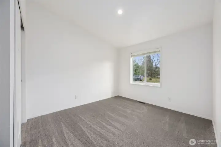 With a vaulted ceiling and generous window, this 2nd bedroom feels larger than expected. The plush mushroom carpet softens the space, and recessed lighting keeps everything feeling fresh and current. Whether it’s used as a bedroom, office, or flex space, the layout and finishes make it feel thoughtfully designed and comfortable.