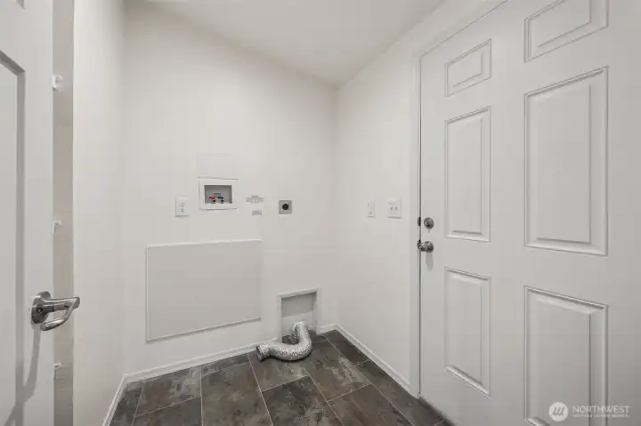 This utility room is ready for you to bring your own washer and dryer, with enough space for a full-size, high-efficiency setup without feeling tight. The vaulted ceiling keeps it feeling open, vinyl flooring makes cleanup easy to double as a mud room as the door to the backyard deck is perfectly placed here too, right off the kitchen. If grilling is your thing, this layout just makes sense. There’s also room to add shelving or upper cabinets, turning this into a smart pantry and utility combo.