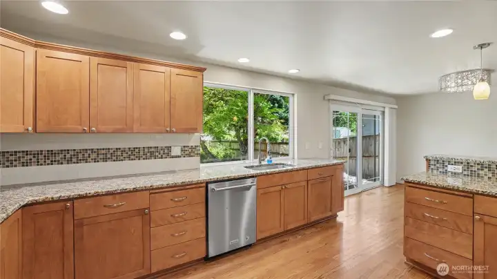 Sparkling countertops offer abundant workspace.  Full-height backsplash adds visual appeal.