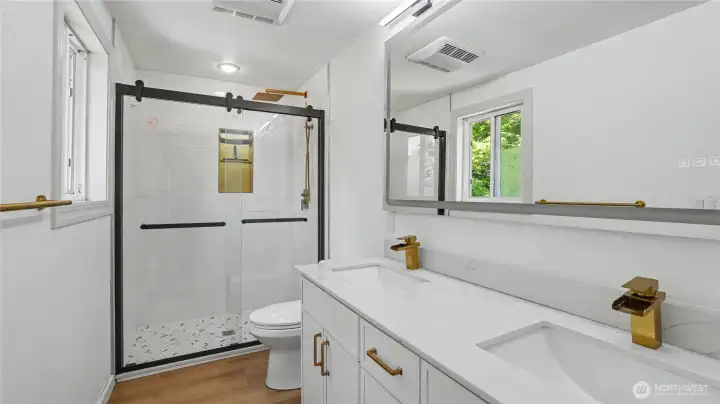 Beautifully updated bathroom with dual sink vanity and large shower.