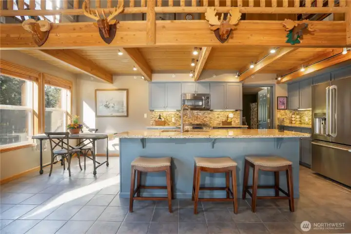 The kitchen island is a great spot to hang out while meals are being prepped! The door beyond leads to the gathering room.