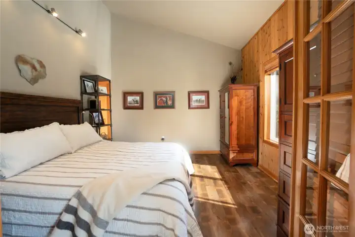 Primary bedroom, with LVP flooring, vaulted ceilings & walk in closet.