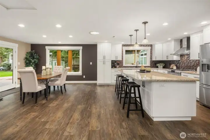 A stunning kitchen remodel with shaker cabinets, quiet-close drawers and pull-outs, granite countertops, stainless steel appliances, and a large eating island. GE dual oven and KitchenAid refrigerator.