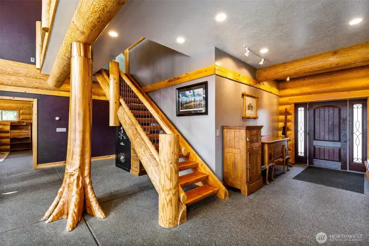 Heated exposed aggregate floors allow the bold live-edge architecture to shine through.  Note the fabulous main beam and the split log stairs.  The interior of the home says "Luxury Lodge" in every detail.