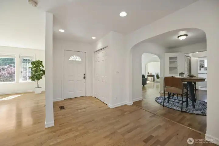 Large foyer with decorative glass door, recessed lighting and adjacent coat closet