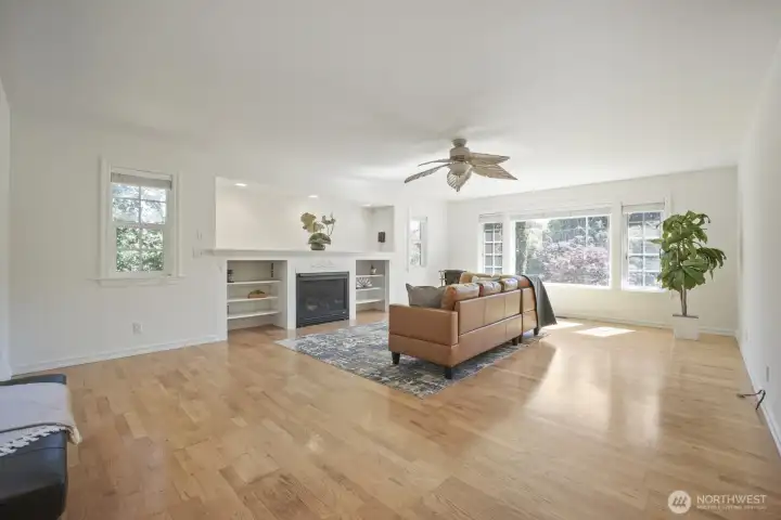 Colossal, East facing living room with many beautiful windows, wood blinds, recessed lighting, ceiling fan, lovely built-in gas fireplace with huge mantle, tiled art nook above, flanked by shelving.