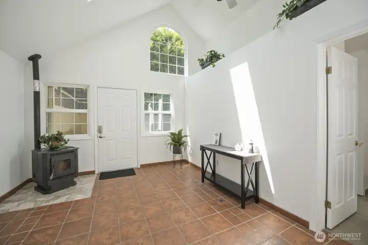 Enter the atrium via the glass paneled door in primary bedroom. Beautiful Spanish style tile, stand alone pellet stove, vaulted ceilings with ample windows, skylight & fan. Separate entrance- great for extended living or short term rental option