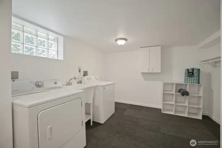 At the bottom of stairs is where you'll find an oversized utility room with utility sink, cabinets, hanging rack, updated carpet- truly an amzing space!