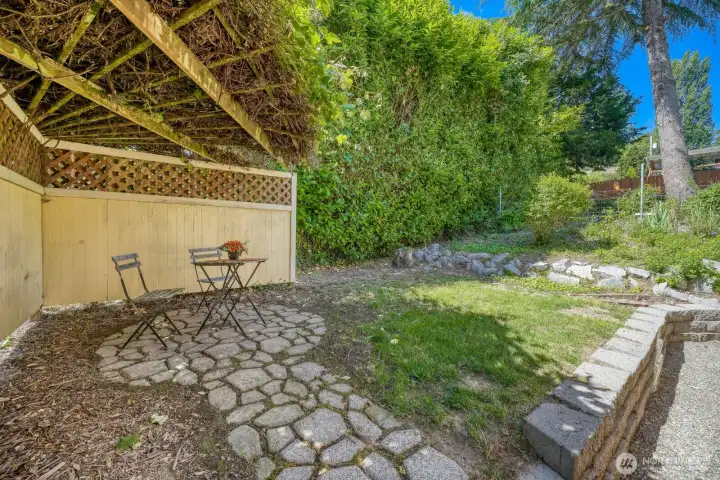 Patio off atrium. So many pavers, brickwork, walkways & terraces, it is really quite amazing. Grottoesque area with grapevine overhang, flanked by privacy fencing.