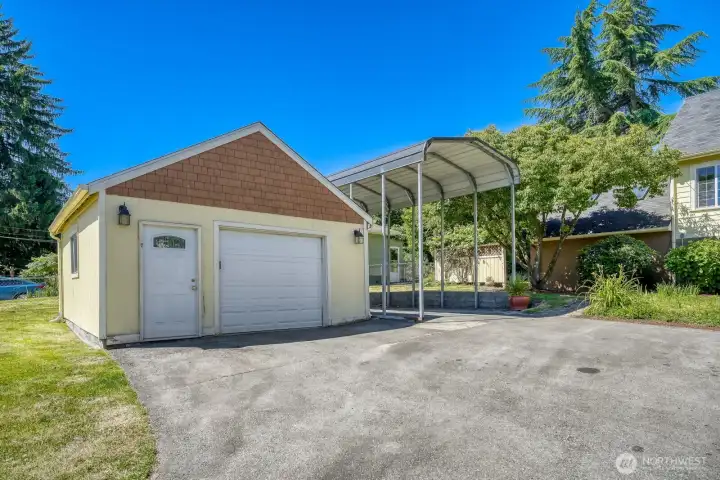 Oversized, detached garage with updated garage door, decorative man door with window & accent peak.  Also, RV carport & parking for 10+ cars off street