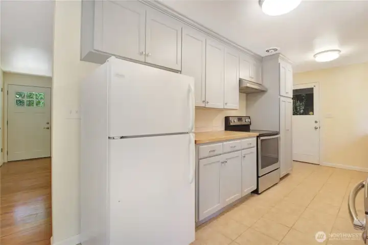 Updated kitchen with freshly painted cabinets and butcher block countertops Updated kitchen with freshly painted cabinets and butcher block countertops