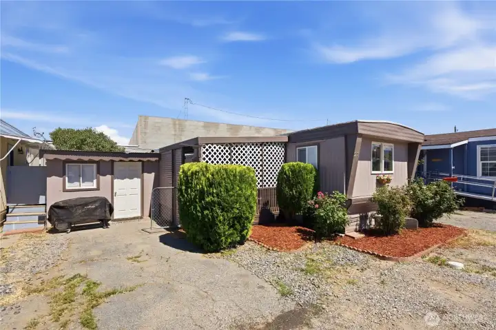 Front exterior of manufactured home in Conifer's Mobile Home Park with covered entry and mature landscaping. Front exterior of manufactured home in Conifer's Mobile Home Park with covered entry and mature landscaping.