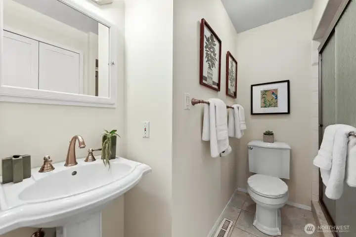 Primary bath with stall shower and pedestal sink.