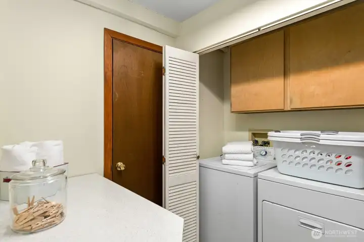 Dedicated laundry room with storage cabinetry and under counter utility sink