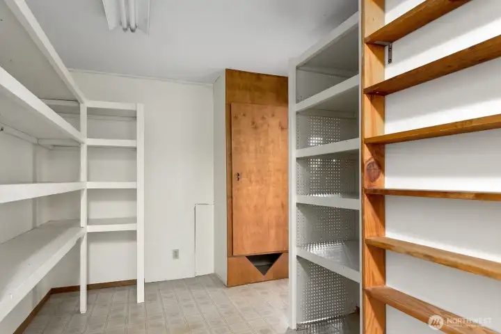 Dedicated storage room with built-in shelving conveniently located next to the laundry room and garage