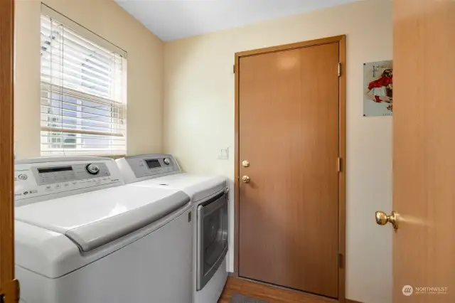 Utility room has cabinetry & a freezer just behind this door and the garage is straight ahead