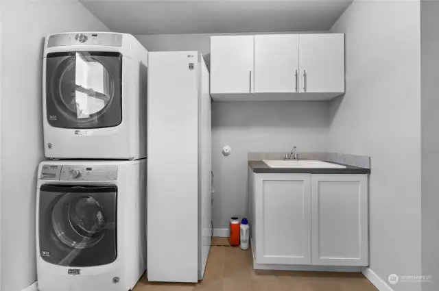 Spacious laundry room includes utility room sink.