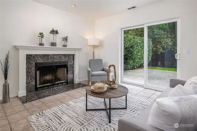 The family room on the lower level with a wood-burning fireplace and sliders to the patio and yard.