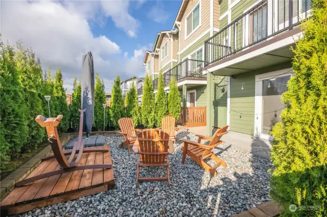 Fully fenced backyard lined with emerald green arborvitae