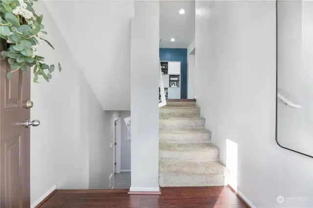 Entry to home with coat closet on the left. Downstairs leads to garage and bedroom, upstairs leads to main floor.