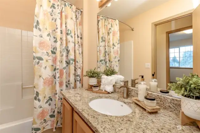 Guest bathroom with tub/shower combination, granite counter, undermount sink and updated hardware.