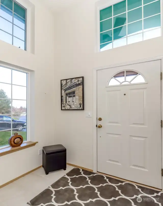 Ascend the charming front stairs to this beautifully maintained split-entry home. Step inside to be greeted by stunning ceramic tile flooring, soaring cathedral ceilings, and an abundance of windows that fill the space with natural light.