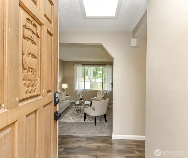 Front door entry facing the sunken living room. Bedrooms are to the left and the kitchen is to the right of the entry.