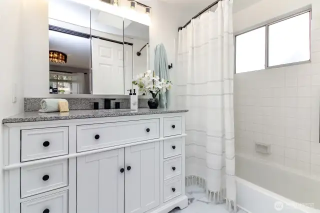 Updated primary bathroom with new vanity, flooring, lighting and door.
