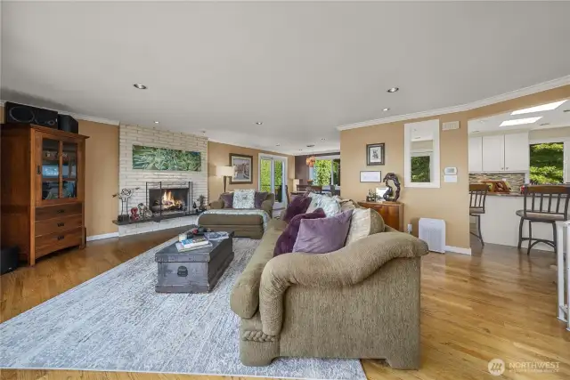 The designer earth tones and warm-toned hardwood flooring create a very calming and soothing atmosphere in this spacious living room. The Brick/Gas-Log Fireplace, Crown Molding and Recessed Lighting add to its comfort, elegance and charm.
