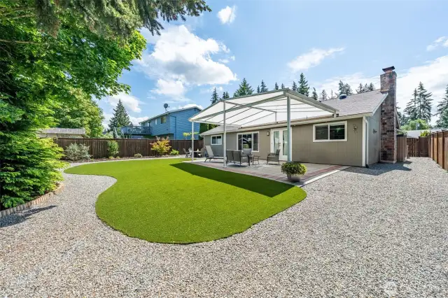 Enjoy your weekends soaking up the backyard versus working in it! You'll find artificial turf here and easy care landscaping! You can see the side storage area with included shed and a place for garbage/recycle cans.