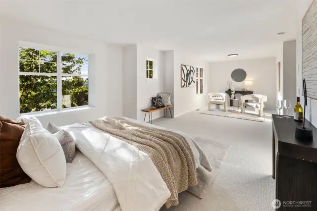 The spacious primary suite is a true retreat, featuring plush new carpeting, generous natural light from multiple windows, and a serene sitting area perfect for reading, relaxing, or morning coffee.