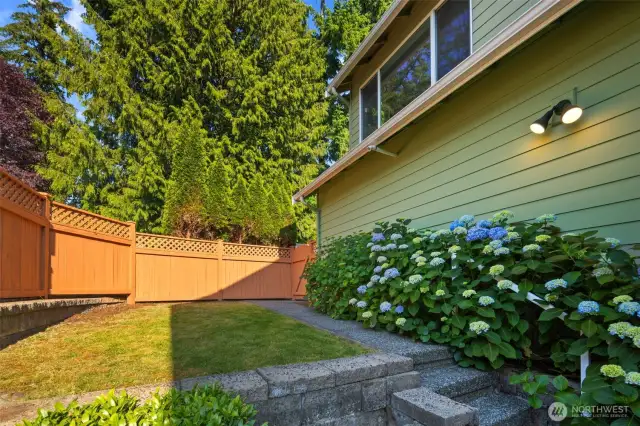 This fully fenced backyard includes gates to the driveway and to the front yard, plus a grassy lawn for pets, play, or gardening.