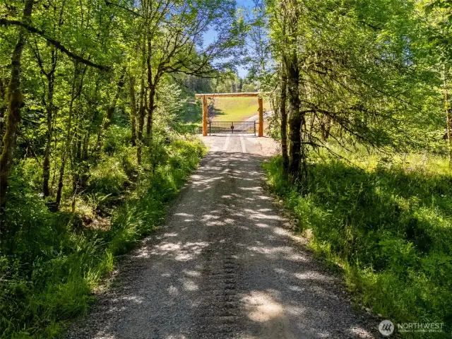 Standing near NE corner looking at entry gate. Translation, the gate is not on the property line but set into the property about 100'