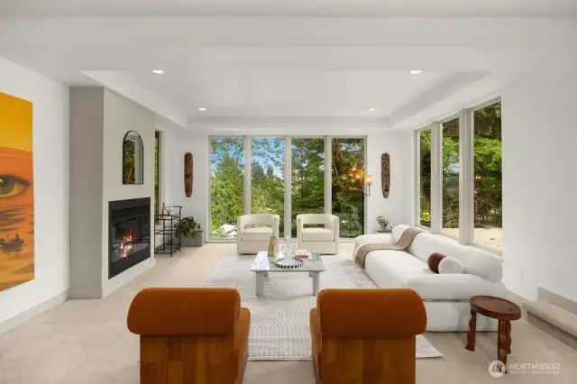 Sunken living room with floor to ceiling windows  for plenty of natural light and stunning view of nature