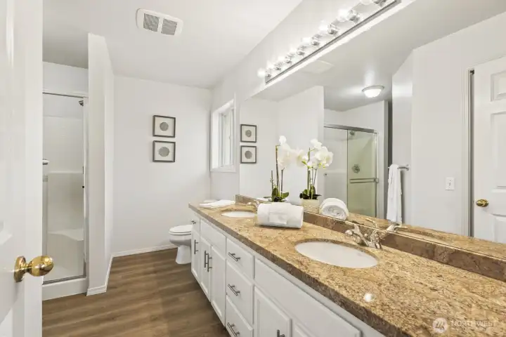 Primary bathroom includes dual sinks, lots of cabinet space, and walk-in shower.