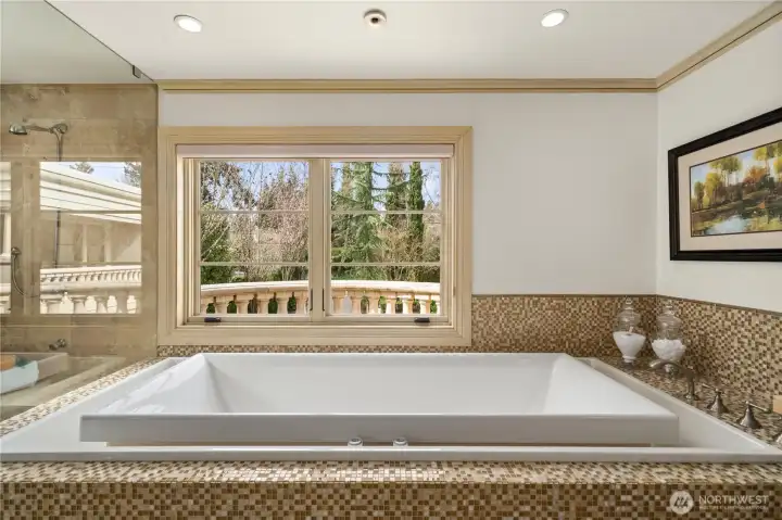 Spa-inspired primary bath featuring a walk-in shower, soaking tub, dual vanities, and refined stone finishes.