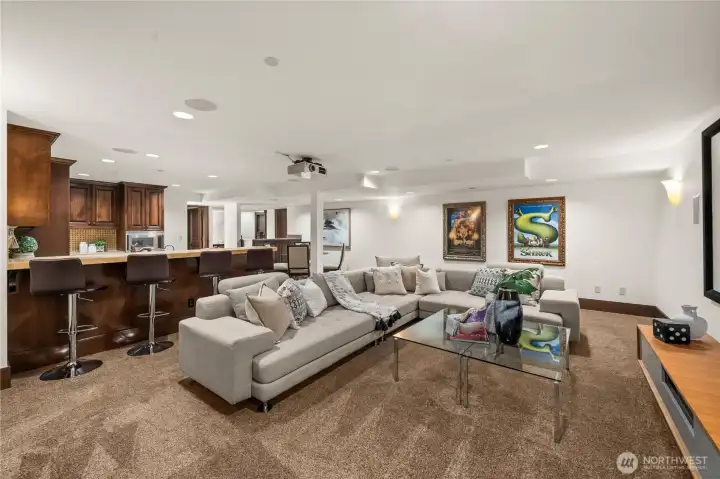 Expansive media lounge with integrated bar seating, designed for entertaining, movie nights, and relaxed gatherings.