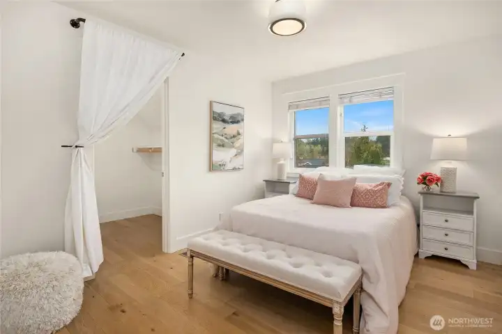 Across the hall from the full bath is a lovely bedroom with walk-in closet, and more of the warm oak flooring.