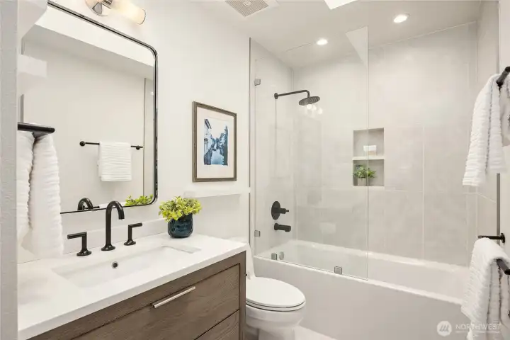 A full bath for the two guest rooms, Restoration Hardware vanity, quartz counter, and Brizo designer faucets & shower system.  This bright room also has a skylite.