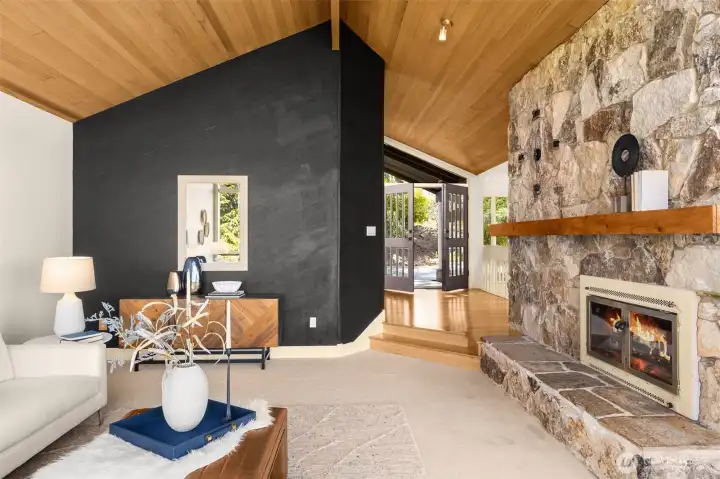 Vaulted wood ceilings, a statement stone fireplace, and rich hardwoods offer a warm nod to mid-century modern design.