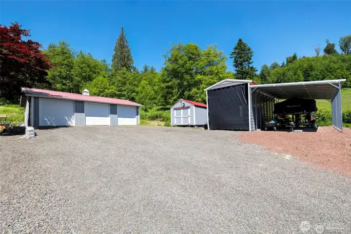 Garage is spacious, covered boat storage, lawn mower shed, and another covered area for an RV