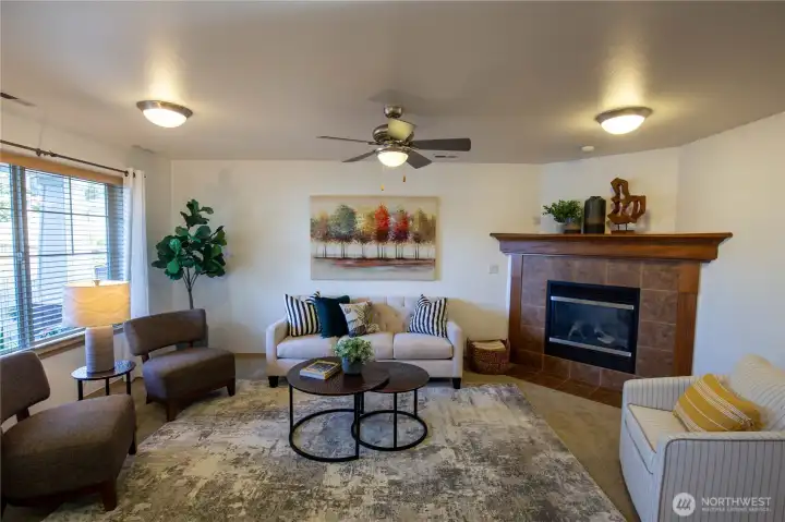 The living room is light and bright with a cozy gas fireplace, lovely mantle and ceiling fan.  There are custom blinds through this home.