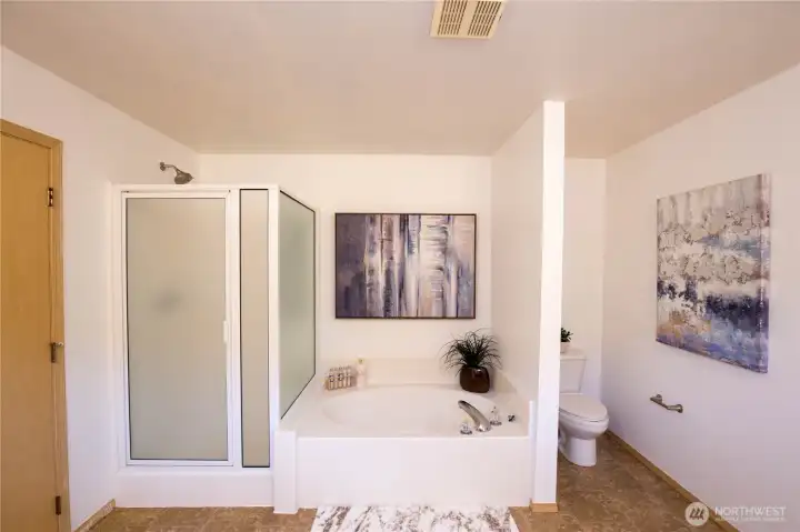 The primary ensuite 5 piece bathroom is spacious with luxurious soaking tub and separate shower.