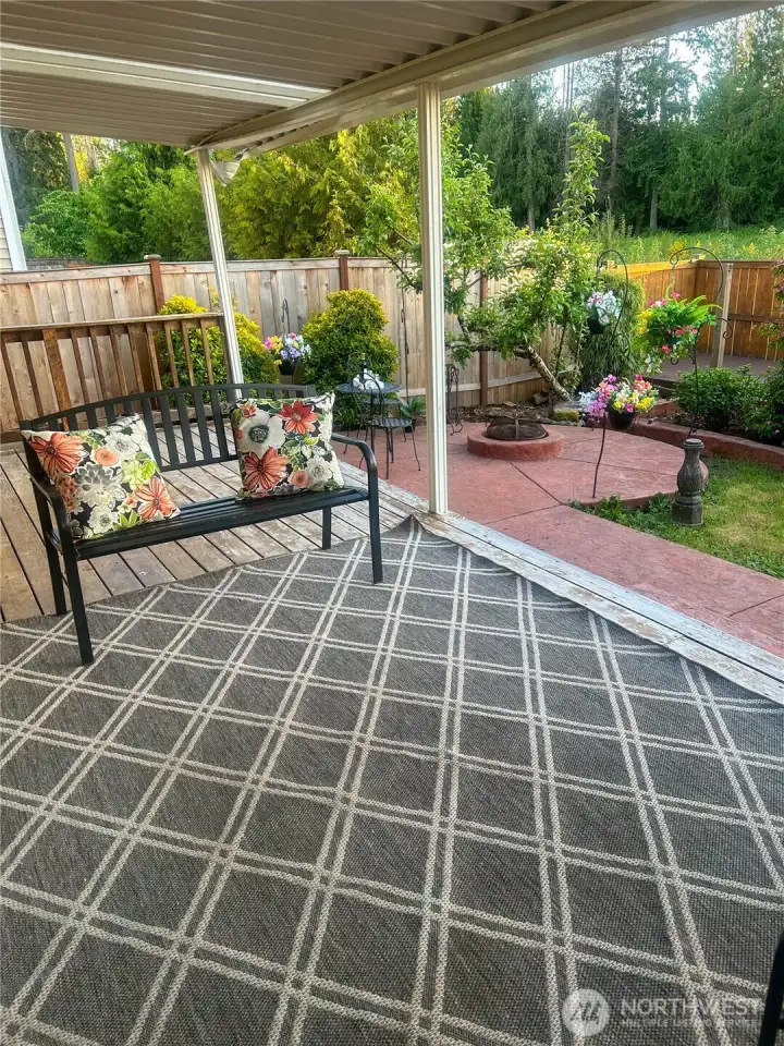 The large covered deck overlooks the back yard and is ready for outdoor living and entertaining.  Relax and enjoy the firepit area, your own private oasis.