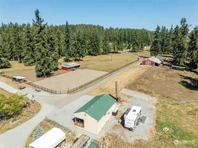 As you enter the property, the large red barn is the first building you come too, followed by arena and tack room with green roof. Current owners have boarded horses. There is also RV parking with hookups here behind the tack room.