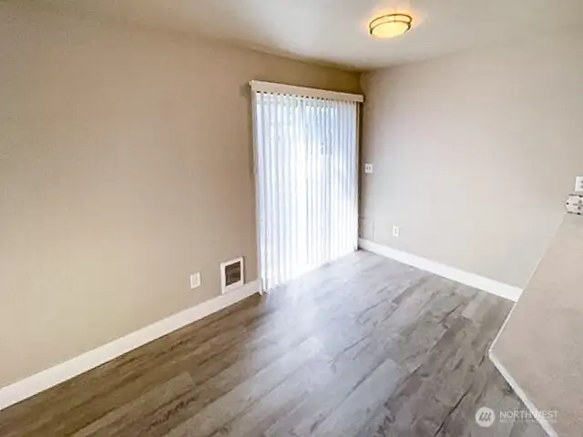 Unit A dining room with a slider leading out to the side yard.