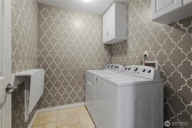 Main floor laundr room with cabinets and folding table.