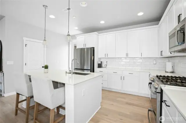 quartz slab, stainless steel apps, gas range, engineered hardwoods