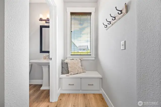 Foyer bench and coat storage. 1/2 bath on left.